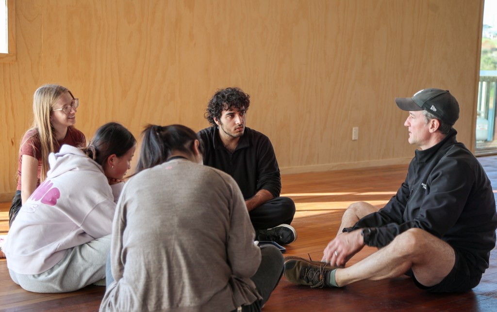 A Good CX Innovation Lab at Fergs Kayaks, Auckland: a leadership group sitting in a circle on the floor, thinking together.